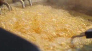 Yağ kabarcıkları ve kızartmalar aşçılar öğle yemeği sırasında yemek hazırlarken.