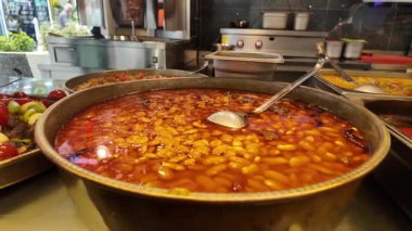 Yoğun bir restoranın mutfağında büyük bir biber tenceresi pişirir..