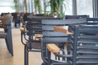 Sandalyeler, müşteriler için hazır masalarla bir kafe alanına kurulur..