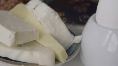 İnsanlar sabahları pazarda farklı peynir türlerini keşfediyorlar..