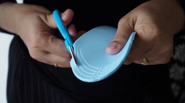 Mavi Ayakkabı Tabanı 'nı Makasla Kesen Ellerin Yakın Çekimi.