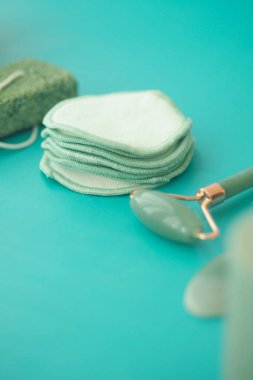 Pamuk bloknotlar turkuaz bir yüzeyde yeşim bir rulonun yanına istiflenir..