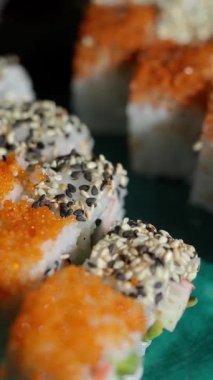 İnsanlar somon yumurtası ve susamlı suşi yiyorlar..