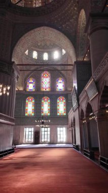 Yüksek kemerli ve parlak camlı bir caminin içini keşfedin..