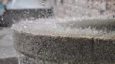 Kalabalık bir şehir meydanındaki çeşmeden su akıyor..