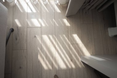 Güneş ışığı mobilyalı bir odada yerde desenler yaratır..