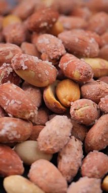 İnsanlar güneşli bir günde markette tuzlu fındıklara bakarlar..