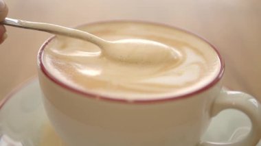 Sabahın köründe bir kafede bir fincan kahve karıştıran biri..