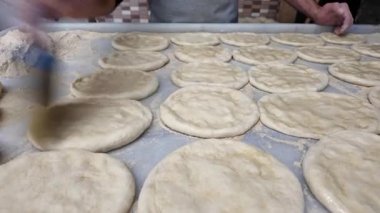 Aşçılar mutfakta hamur üzerinde çalışır ve ekmek pişirmek için ekmek hazırlarlar..