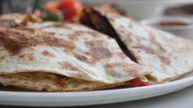 İnsanlar restoranda salsa soslu quesadilla yiyorlar..