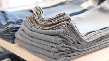 Birçok katlanmış kot pantolon müşteriler için bir gösteri masasına yerleştirilir..