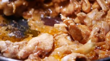 Tavuk tavada pişiriliyor. Fırında baharat ve yağ var..