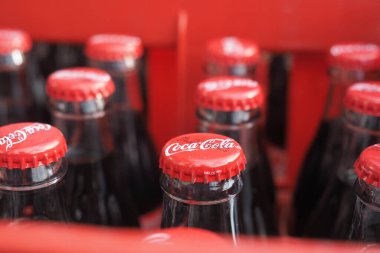 Coca-Cola şişeleri satılık bir dükkandaki kırmızı bir sandığa konur..