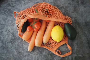 Bir çantada havuç, domates, limon ve avokado bulunur..