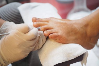 Bir kişi öğleden sonra bir salonda ayak bakımı alır..