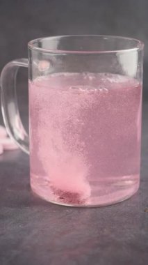 Pembe Fışkırtan Tablet Cam Kupada Çözünüyor.