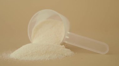 Sarı arka planda süt tozunu karıştırıp ölçmek .