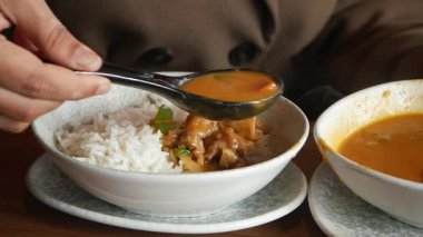 Bir el bir kaşık dolusu pilav ve çorbanın yanında güveç tutar..