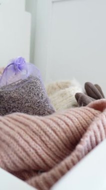 Bir kutuda kalın kıyafetler ve lavanta kesesi koleksiyonu..