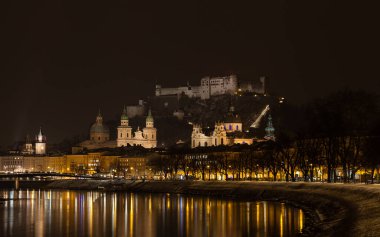Salzburg, Avusturya 'da Salzach Nehri' nin karşısında gece görüşü. Arka planda Hohensalzburg Kalesi var..