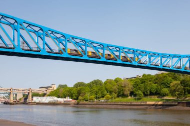 İngiltere 'nin kuzeydoğusundaki Tyne Nehri üzerindeki Kraliçe II. Elizabeth köprüsü. Tyne ve Gateshead 'den Newcastle' a giden bir tren görüldü..