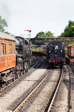 İki buhar treni Goathland İstasyonu 'ndan geçiyor, Kuzey Yorkshire Moors Demiryolu' nda. Demiryolu, İngiltere 'de Kuzey Yorkshire Moors National' da bir miras demiryoludur..