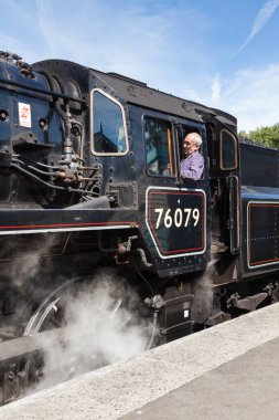 76079 numaralı buharlı trendeki sürücünün yakın çekimi. Tren Grosmont İstasyonu 'ndan Kuzey İngiltere' deki Kuzey Yorkshire Moors Demiryolu 'na doğru yola çıkmaya hazırlanıyor..