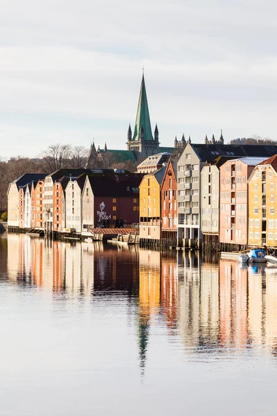Norveç, Trondheim 'daki eski ahşap depolara doğru Nidelva Nehri' nin karşısındaki manzara. Arka planda Nidaros Katedrali var..