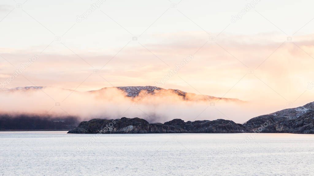 Norwegian coastline.  A winter view of the rocky coastline shrouded in mist close to the Norwegian town of Kirkenes.