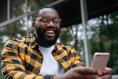 Cep telefonu kullanan Afrikalı bir adam. Duygusal adam elinde akıllı telefon, film izliyor.