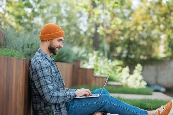 IT specialist or programmer developing and testing software using laptop computer, working freelance project sitting at workplace. Successful business and career concept. Smiling man working from home