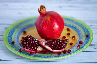 Taze olgun nar parlak, güzel bir tabakta yatıyor. Bir nar tanesi ki, tohumları bir tabağa saçılmıştır.