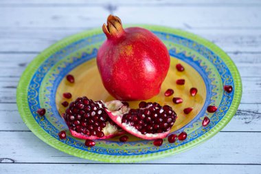 Taze olgun nar parlak, güzel bir tabakta yatıyor. Bir nar tanesi ki, tohumları bir tabağa saçılmıştır.