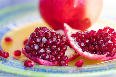 Taze olgun nar parlak, güzel bir tabakta yatıyor. Bir nar tanesi ki, tohumları bir tabağa saçılmıştır..