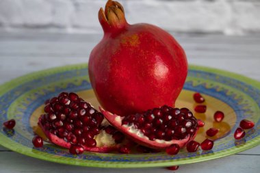 Taze olgun nar parlak, güzel bir tabakta yatıyor. Bir nar tanesi ki, tohumları bir tabağa saçılmıştır..