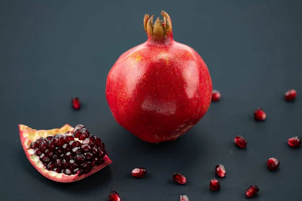 Fresh Ripe Pomegranate Black Background Cut Pomegranate Its Seeds Scattered — Stock Photo, Image