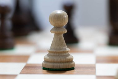 Satranç tahtasında tahta satranç oynamak. Taktik ve strateji. Siyah ve beyaz şekiller