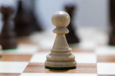 Satranç tahtasında tahta satranç oynamak. Taktik ve strateji. Siyah ve beyaz şekiller