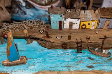 Renkli eski minyatür ahşap evler denizin ya da nehrin setinde duruyor. Balık ağları. Tekne kıyıya demirli. Balıkçıların köyü