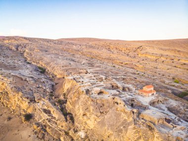 Ortasında bazilika ve volkanik kaya oluşumları olan Uplistsikhe mağara kasabasına yakın hava görüntüsü. Gürcistan 'ı gezmek ve gezmek.