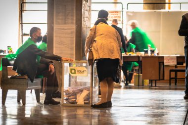 Tiflis, Gürcistan Cumhuriyeti. 31 Ekim 2020. Gürcistan parlamento seçimleri. Kadın oylarını yakındaki gardiyana veriyor. Gürcistan Cumhuriyeti 'nde güvenlik ve oylama 20.20