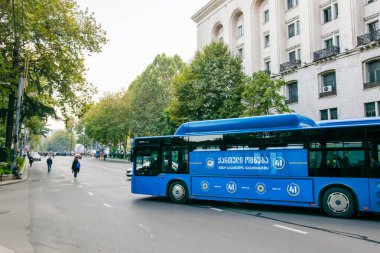 1 november, 2020. Tbilisi.Republic of Georgia. Closed Rustaveli avenue street  during protest with blue city bus turning with election agitation on. clipart