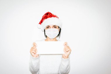 Beyaz maskeli kadın boş beyaz zarf tutuyor. İzole edilmiş. Xmas mesajı ve hediye fikirleri kavramı..