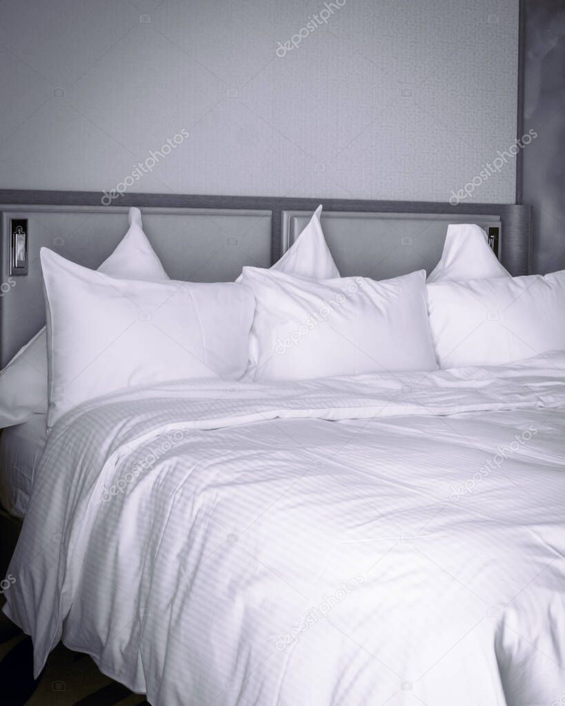 Grey Monochrome image of bed with white sheets. Corona virus patients luxury hotel accomodation concept. 2020