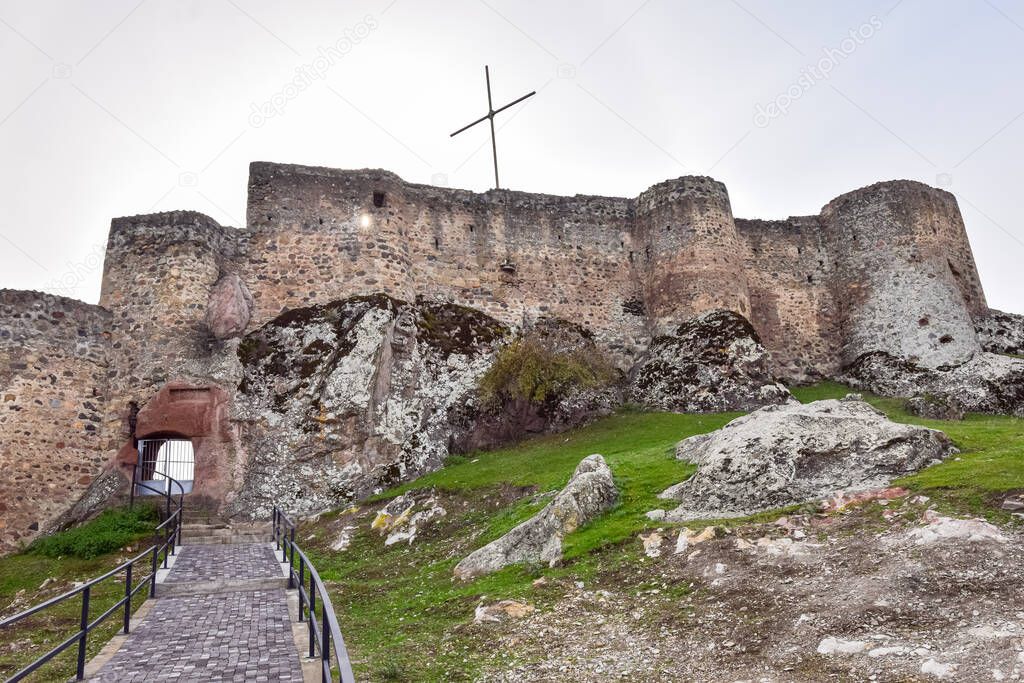 Kveshi fortress with pathway and cross on top. Historical and cultural heritage n Georgia.