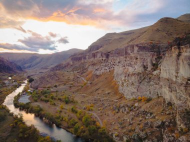 Vardzia mağara şehrinin yukarıdan havadan bakış açısı. Paravani nehri ve sonbahar doğası ön planda. Tarihsel unesko alanları Georgia.