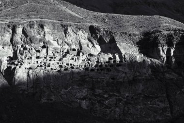 Vardzia- mağara şehrinin siyah ve beyaz dramatik manzarası gün doğumunda gölge koşullarında. Kafkaslarda benzersiz ve gizemli yerler.