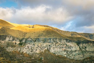 Vardzia mağara şehrinin yukarıdan havadan bakış açısı. Paravani nehri ve sonbahar doğası ön planda. Tarihsel unesko alanları Georgia.