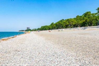 Açık bir yaz gününde, uzaktaki insanlarla sahili görmek.