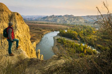Erkek turist ayakta duruyor ve Mijniskure manzarasının tadını çıkarıyor. Vashlovani doğa rezervi